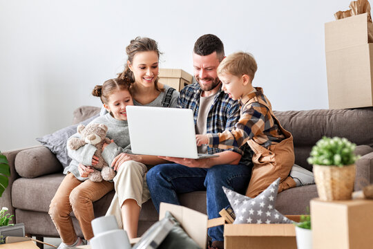 Cheerful family using laptop during relocation in new apartment