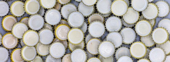 Texture background with group of many beer bottle caps or soft drinks caps in panorama format