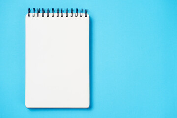 School notebook on a paper blue background, spiral notepad and craft cardboard pen