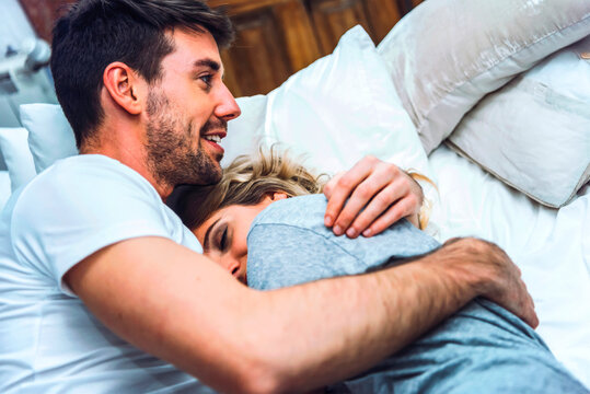 Happy couple cuddling in bed
