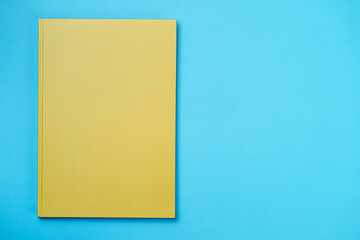 Green Leather notebook on paper blue background, notepad mock up, top view shot