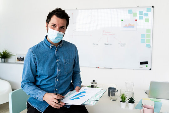 Portrait of business man wearing protective mask in office¬†