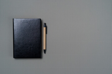 Black leather notebook on a paper gray background, notepad mock up, top view shot