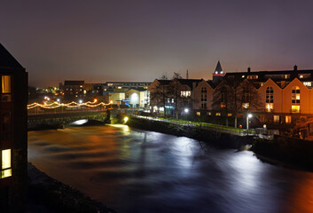 Fototapeta na wymiar Long exposure photo of rushing water at O'Brien's bridge on the river Corrib at night in Galway city