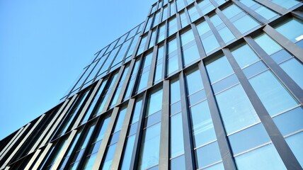 Obraz premium Glass facade of the buildings with a blue sky. Skyscrapers in the business city center.. Background of modern glass buildings. 