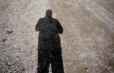 Man shadow on the gravel road during sunny day in Golyazi Bursa.