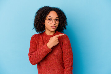 Fototapeta premium Young african american mixed race woman isolated smiling and pointing aside, showing something at blank space.