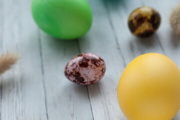 Colored Easter eggs on a light wooden background. Easter holiday with colored eggs, close-up
