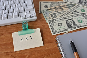 On the desk there were bills, a keyboard, and a word book with the word Asset Backed Security written on it.