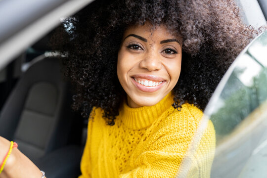 Happy woman smiling while driving car