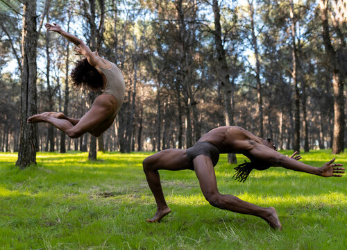 Two professional dancers performing in underwear in middle of forest