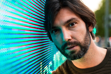 Portrait of man leaning on fence displaying digital data