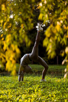 Athlete stretching while bending over backwards at park