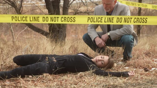 Detective examines body of deceased female jogger behind police tape on grass field