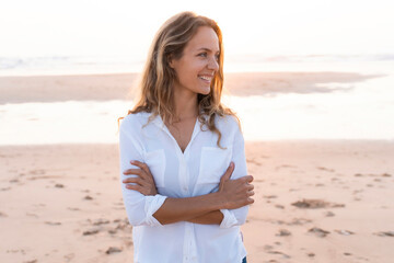 Smiling woman with looking away while standing at beach