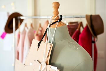 Cardboards hanging on dressmaker's model with straight pins at design studio