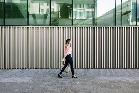Spain, Barcelona, Young businesswoman walking in city