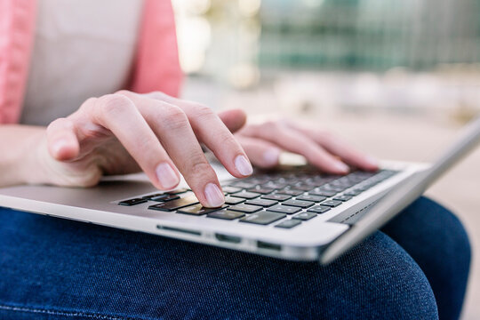 Hands of businesswoman using laptop outdoors