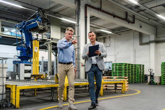 Business colleagues discussing while walking in factory