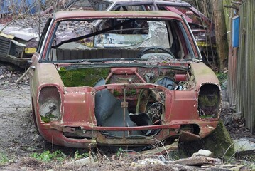 one brown old disassembled car on the ground on the street