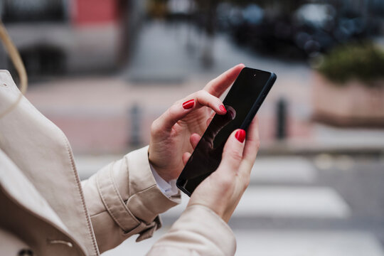 Mid adult woman using smart phone outdoors