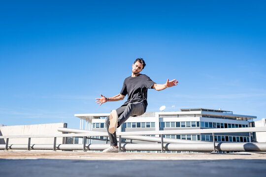 Young man dancing while standing on rooftop