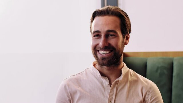 Close up portrait of cheerful talkative man talking to friend, telling joke and laughing, sitting in cafe