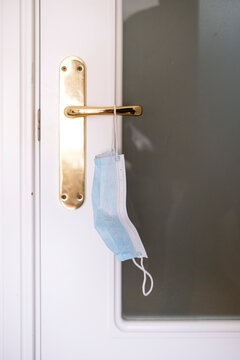 Close-up of face mask hanging on door handle