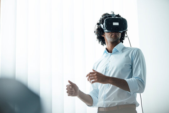 Young male entrepreneur wearing virtual reality headset in board room at office