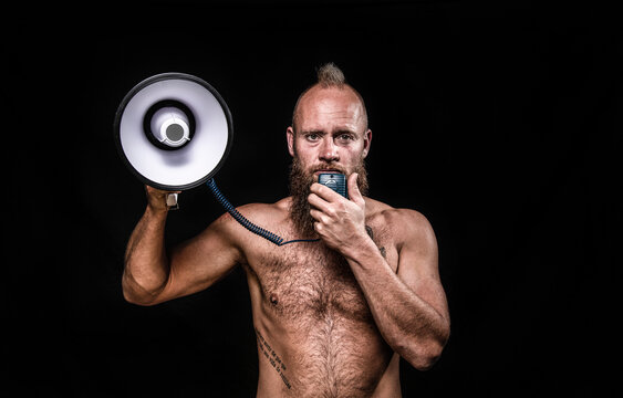 Male viking talking through megaphone against black background in studio