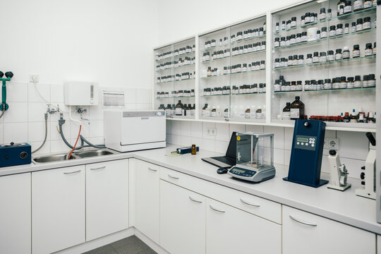 Laptop by device and containers arranged in chemist store