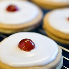 Shortbread biscuits with white icing and a cherry