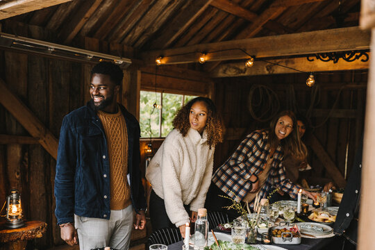 Smiling male and female friends looking away during social gathering