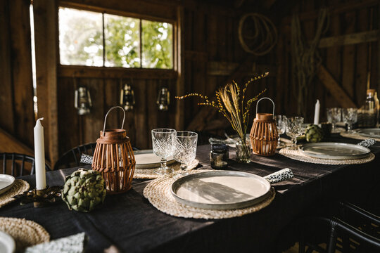 Plates and glasses arranged on dining table during social gathering