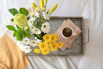 Hot tea and bouquet of flowers on a tray