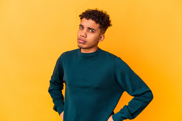 Young african american curly man isolated on purple frowning face in displeasure, keeps arms folded.