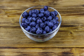 Fresh blueberry in glass bowl on a wooden table