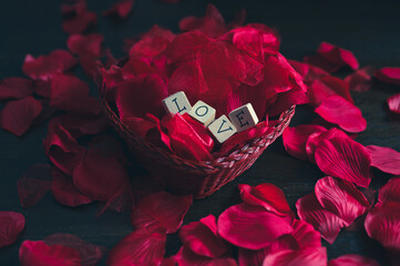 Love letters on a basket filled with rose petals