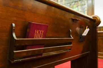 Close up of bible on wooden church pew