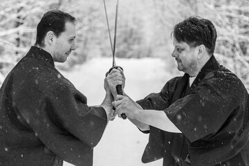clinch in a duel of two samurai warriors on an empty road in a winter forest
