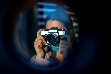 The photographer takes pictures with a retro camera. A look through the lens concept - 410279883