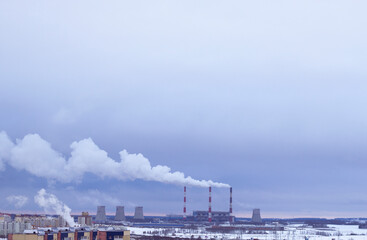 smoke from the pipes of heating station, pollution and environment, winter cityscape and ecology