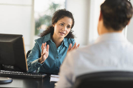 Woman interviewing man at desk