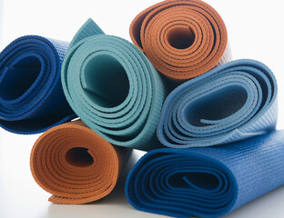 Stack of exercise mats on white background