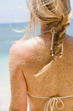 Woman's back with sticking sand