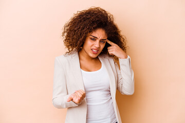 Young african american woman isolated on beige background showing a disappointment gesture with forefinger.