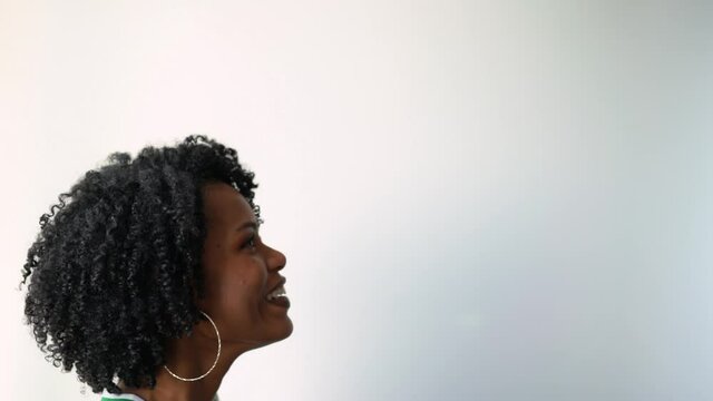 Beautiful black African woman with curls trying to spin basketball on her finger