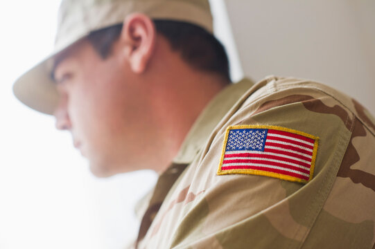 Man wearing military uniform looking through window