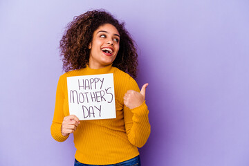 Young African American woman holding a Happy motherâ€™s day placard isolated points with thumb finger away, laughing and carefree.