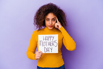 Young African American woman holding a Happy motherâ€™s day placard isolated pointing temple with finger, thinking, focused on a task.